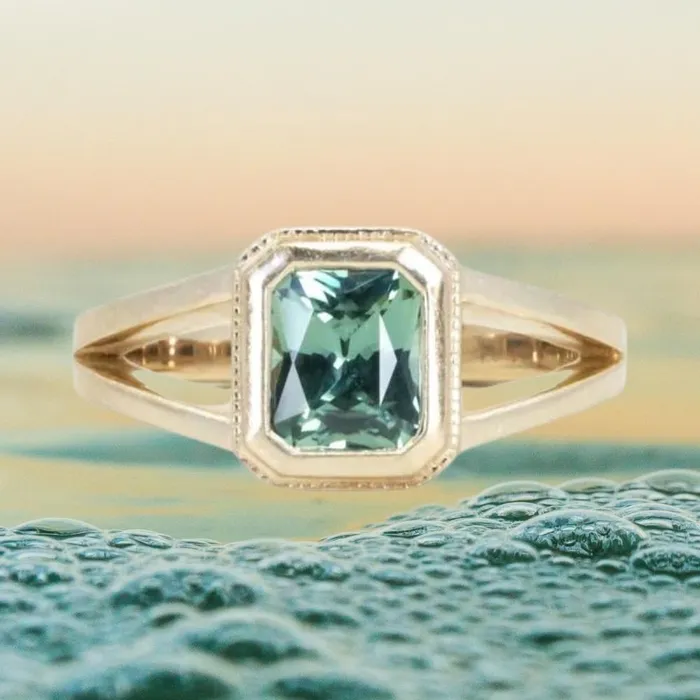 Anueva Jewelry Rings 120ct Radiant Cut Seafoam Montana Sapphire Split Shank Bezel Ring with Milgrain in 14k Yellow Gold Anueva Jewelry Rings 120ct Radiant Cut Seafoam Montana Sapphire Split Shank Bezel Ring with Milgrain in 14k Yellow Gold